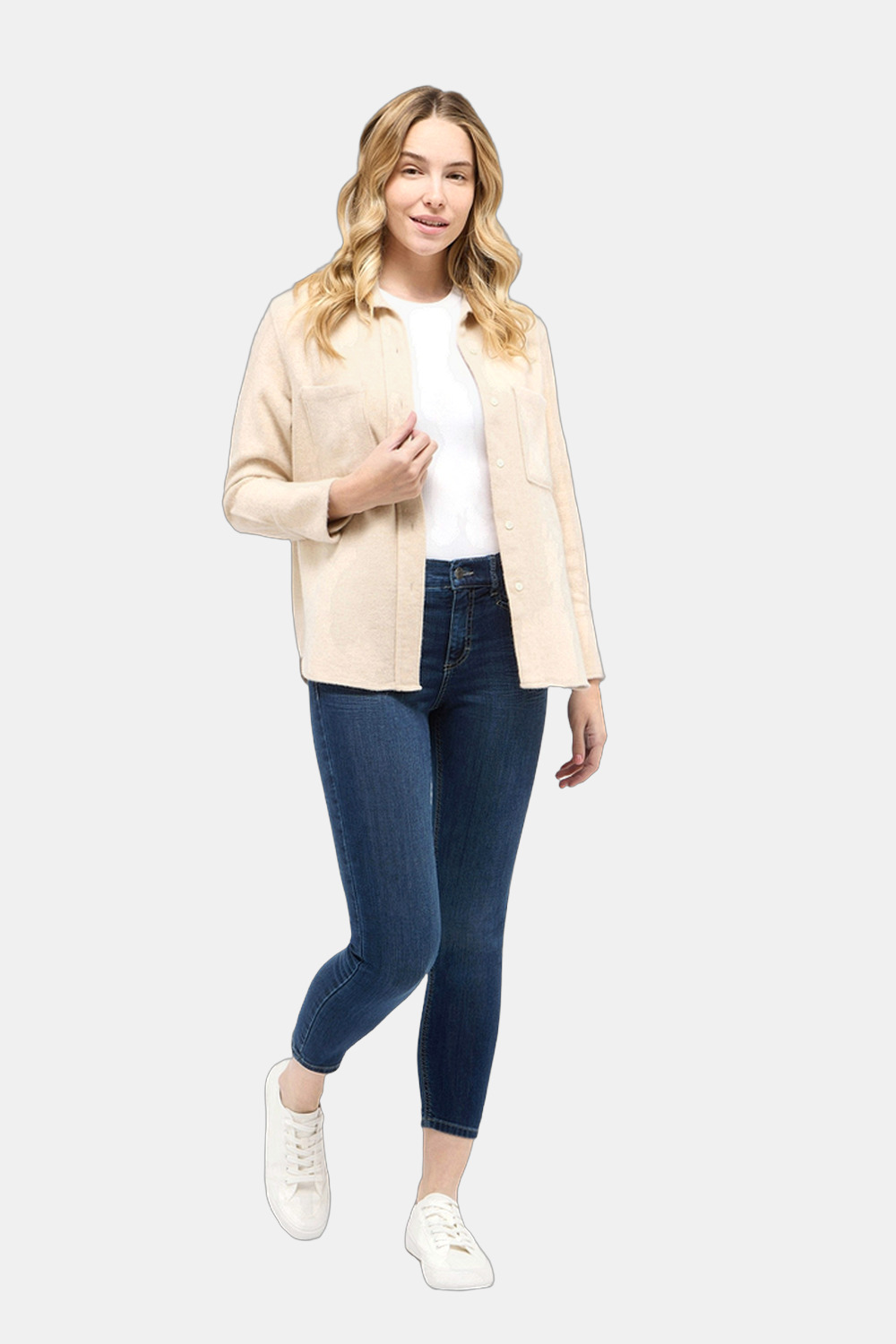 Slim Damen Hose mit Sneakern und leichtem Mantel an einem kühlen Frühlingstag in der Stadt